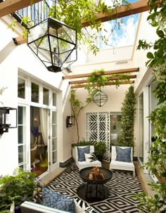 an outdoor living area with white furniture and plants