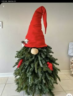 an elf's hat on top of a christmas tree in the middle of a room