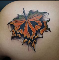 an orange and black butterfly tattoo on the back of a woman's shoulder