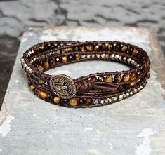 Triple wrap bracelet with 4mm Tiger Eye faceted round beads and brass hex beads hand-strung on leather cord and finished with a bee button. Triple Wrap Bracelet, Charleston Sc, Tiger Eye, Leather Cord, Tigers, Round Beads, Wrap Bracelet, Bee, Brass