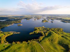 an aerial view of a lake surrounded by green fields