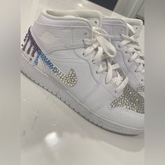 This Is A Pair Of Size 7y (Fits Like An 8.5 Adult) Jordan 1 Mid Triple White Sneakers With Customized Crystal Ombr Blue And Purple On The Swoosh And Vamp. Missing A Couple Of Crystals As Shown And Honestly Can’t Tell Unless Scrutinizing It. Worn Only Once!! Super Cute For Any Party, Event, Mitzvah Etc. Jordan 1 Mid Triple White, Nike Shoes Jordan, Shoes Jordan 1, Nike Shoes Jordans, Jordan 1 Mid, Blue Ombre, Kids Nike, Party Event, White Nikes