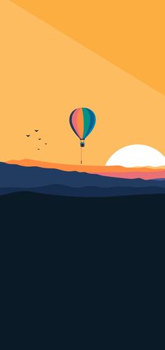 a hot air balloon flying over the ocean at sunset