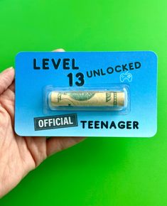 a person holding up a small battery with the words level 13 unlocked on it