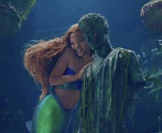 a mermaid hugging a man in the water