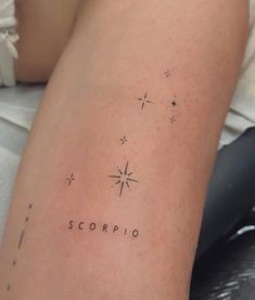 a woman's leg with the word scorpio written on it and stars