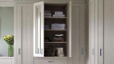 a bathroom with white cabinets and drawers next to a mirror on the wall in front of it