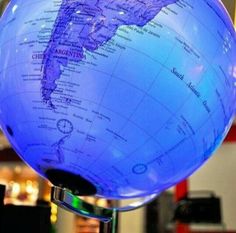 a blue illuminated globe sitting on top of a table