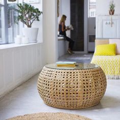 a living room filled with furniture and a woman sitting on the couch in the background