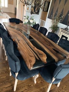 a dining room table made out of wood and blue velvet chairs