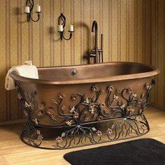 an ornate bathtub in the middle of a wooden floor