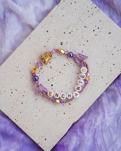 a bracelet with beads and charms on it sitting on top of a piece of cloth