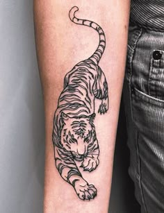 a black and white tiger tattoo on the arm