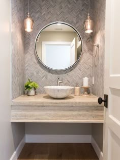 a bathroom sink with a mirror above it and lights on the wall next to it