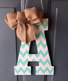 a door hanger with a bow hanging on it's letter and the letters a - zigzag