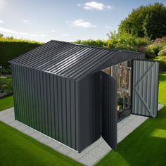 a small metal building sitting on top of a lush green field