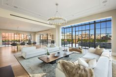 a living room with white couches and large windows