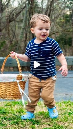 a little boy holding a basket and walking in the grass