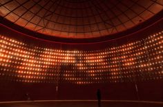 a person standing in front of a stage with lots of lights on the walls and ceiling