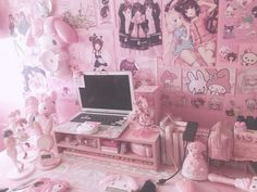 a laptop computer sitting on top of a desk in a room filled with pink decorations