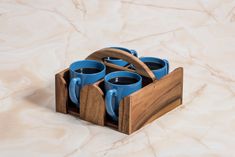 three blue mugs in a wooden holder