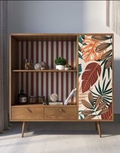 a wooden cabinet with plants and other items on it's side, in front of a striped wall