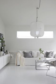 a white living room filled with furniture and decor