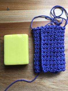 a blue and yellow object sitting on top of a wooden table next to a rubber block