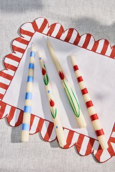 three candles sitting on top of a red and white paper plate next to each other