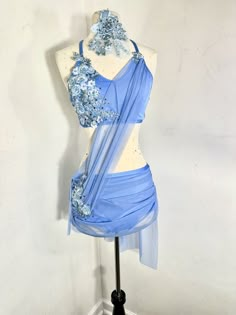 a mannequin is dressed up in a blue dress with flowers on the bust