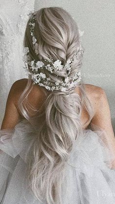 the back of a woman's head wearing a wedding dress with flowers in her hair