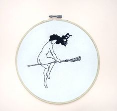 a drawing of a woman holding a broom in front of a white wall behind it