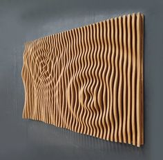 a wooden wall hanging on the side of a gray wall next to a black wall