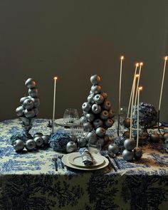 a table topped with silver balls and candles