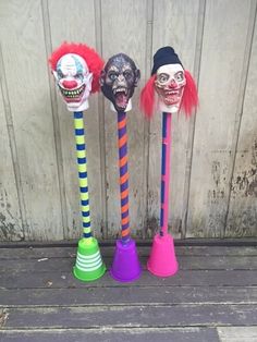 three different colored plastic clown heads on top of cones