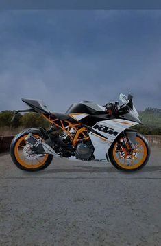 an orange and white motorcycle parked on the street