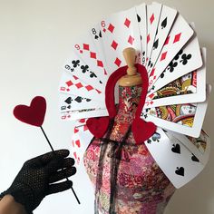 a mannequin holding playing cards and a fan