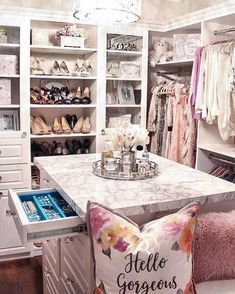 an organized closet with white cabinets, drawers and shelves filled with personal items such as shoes