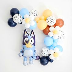 an assortment of balloons are arranged in the shape of a dog and balloon garlands