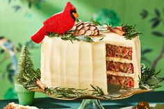 a christmas cake with frosting and a cardinal decoration on top