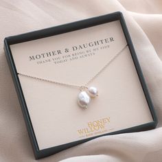 a mother and daughter necklace in a gift box