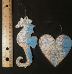 two seahorses are hanging on a map ornament next to a ruler