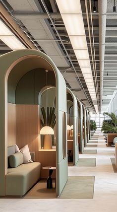 an office lobby with couches, tables and lamps on the walls in front of them