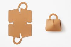 a handbag next to a cut out piece of paper with holes in it and a bag hanging on the wall