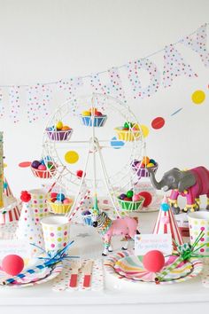 a carnival themed birthday party with cupcakes, cake and circus animals on the table