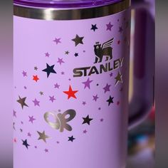 a purple travel mug with stars and the word stanley on it's side is shown