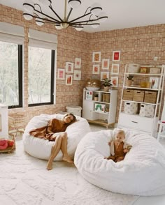 two women laying on bean bag chairs in a room with brick walls and flooring