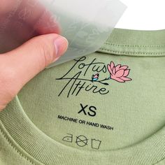 someone is holding up a t - shirt with the words lotus nature xs printed on it