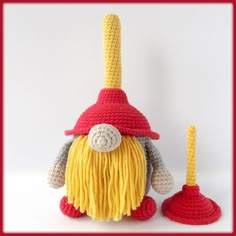 a crocheted gnome with a yellow beard and red hat is next to a toothbrush holder