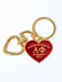 a red heart shaped keychain with the words please return to ao written on it